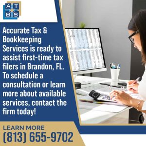 A person in glasses works at a computer displaying financial data